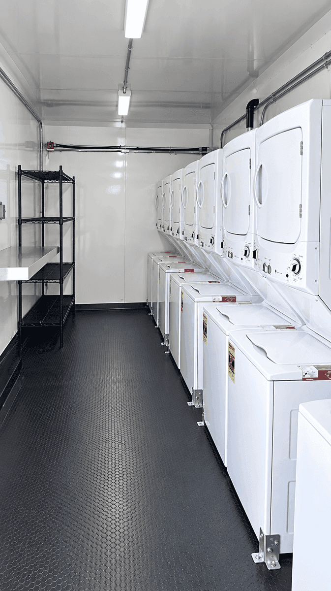 Commercial washer and dryer equipment inside a mobile laundry trailer